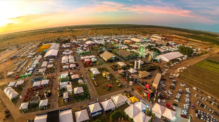 Vista aérea de feira agropecuária no Oeste da Bahia com estandes, máquinas agrícolas e grande público