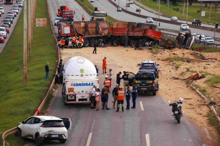 Carreta tombada na Epia Norte, no Distrito Federal, com carga de soja espalhada pela pista após acidente.