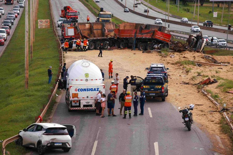 Carreta tombada na Epia Norte, no Distrito Federal, com carga de soja espalhada pela pista após acidente.