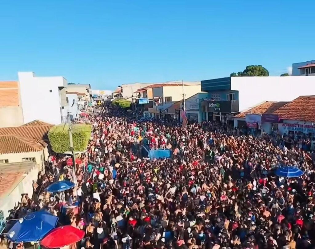 Multidão reunida no circuito do Carnaval de Correntina com trio elétrico e foliões ocupando a avenida durante a noite