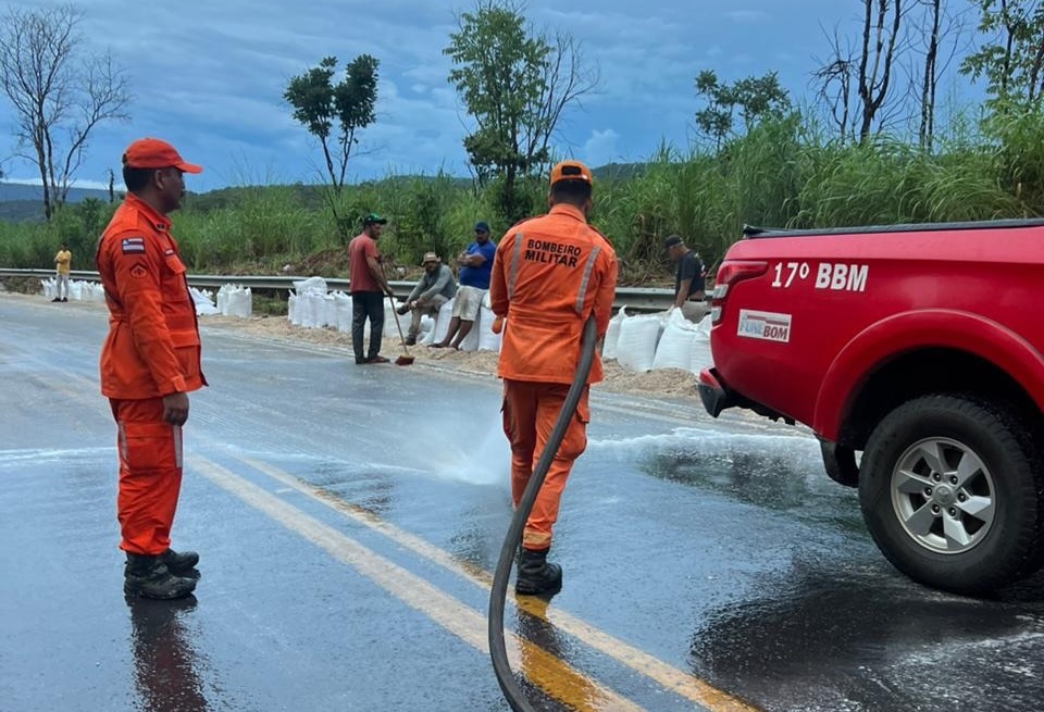 Carga de feijão espalhada na BR-242 após tombamento de semi-reboque em Barreiras, com atuação do Corpo de Bombeiros na limpeza da pista