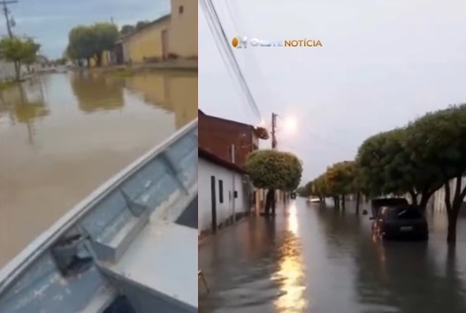 Morador trafega de barco em rua alagada após chuva intensa em Santa Maria da Vitória, no oeste da Bahia.