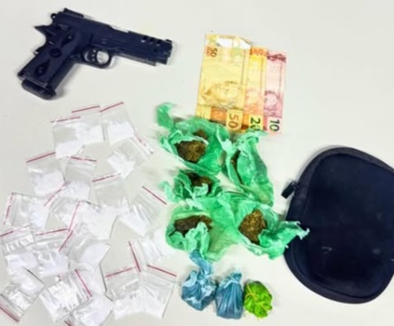 Materiais apreendidos pela Polícia Militar durante abordagem em festa em Santa Rita de Cássia, incluindo drogas e simulacro de arma