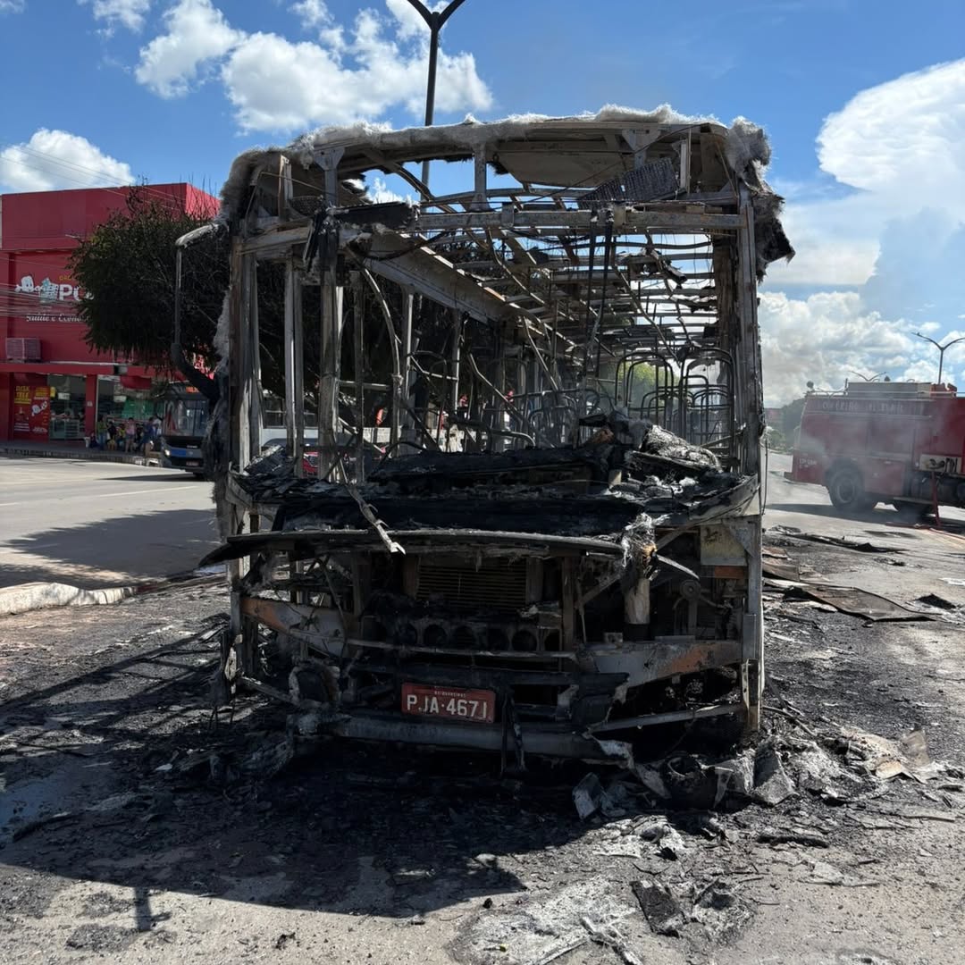 Ônibus coletivo em chamas sendo combatido por bombeiros no centro de Barreiras, com fumaça intensa e atuação de equipes de emergência