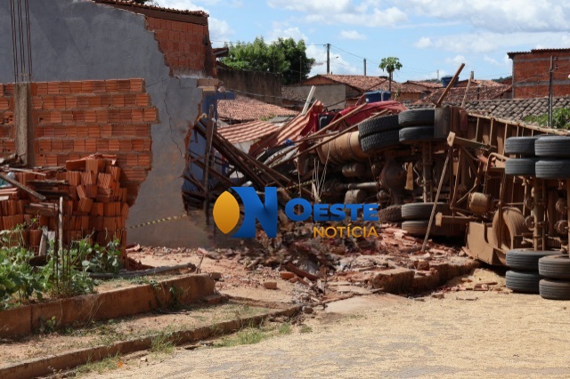 Carreta bitrem tombada após invadir residência em São Desidério, com carga de soja espalhada pela rua
