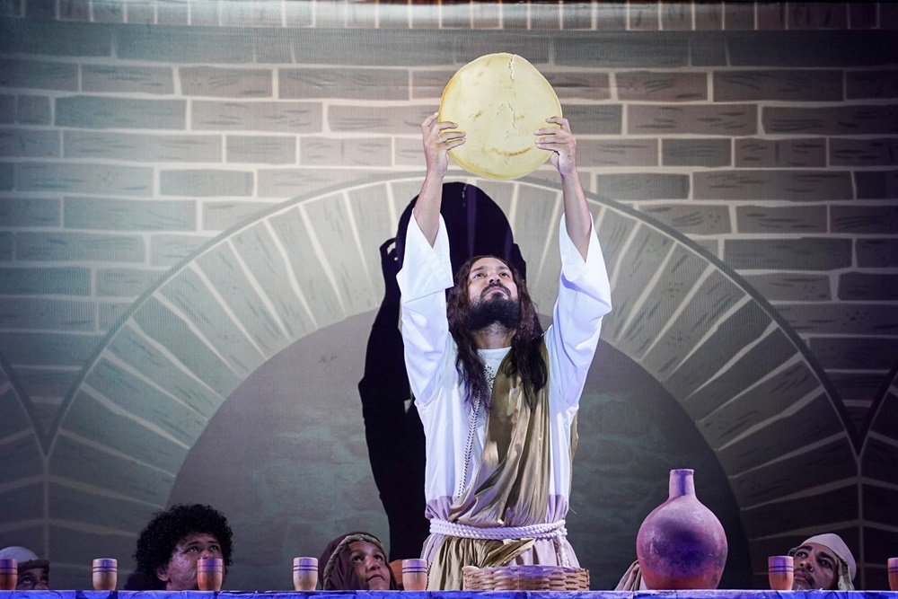 Apresentação da Paixão de Cristo com atores encenando a Via Sacra em praça pública