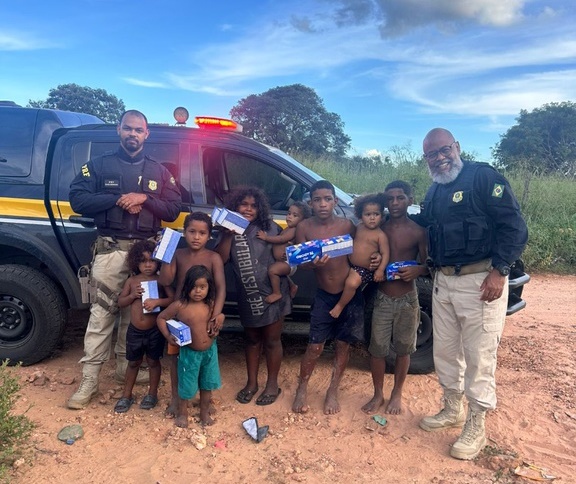 Policiais rodoviários federais distribuem chocolates para crianças em comunidade carente às margens da BR-242, em Barreiras (BA)