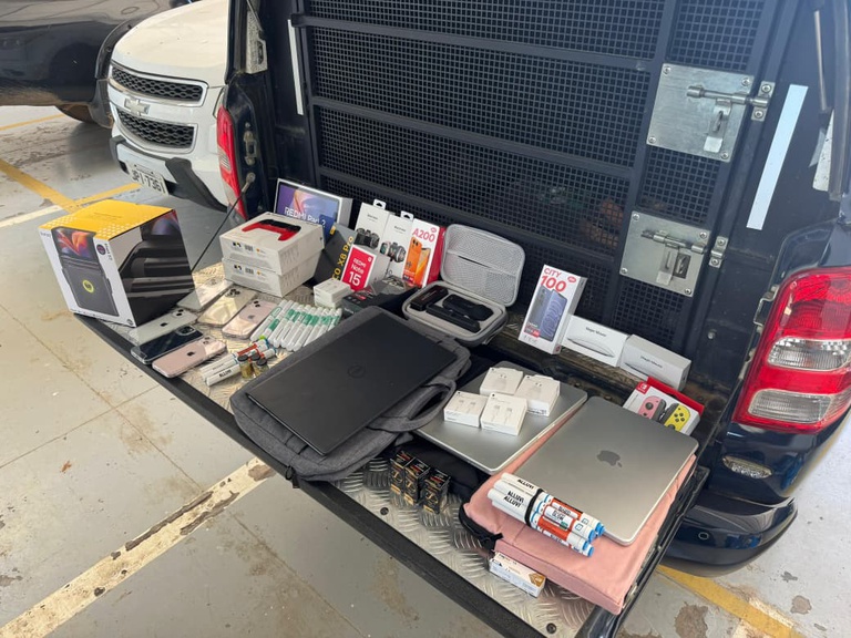 Policiais da PRF exibem medicamentos irregulares, anabolizantes, celulares e eletrônicos apreendidos durante fiscalização na BR-135, em Formosa do Rio Preto.