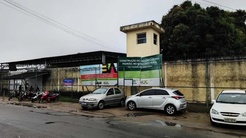 Viatura de segurança em frente ao Conjunto Penal de Feira de Santana durante operação de buscas por detento foragido.