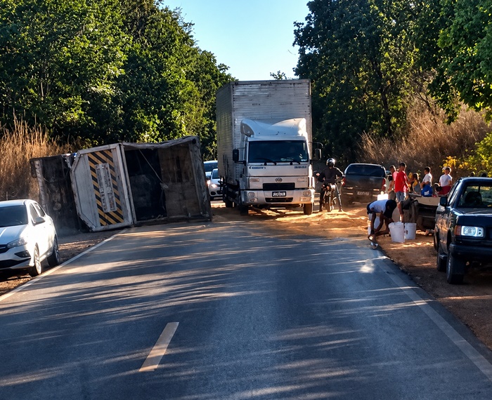 Carreta carregada com milho tombada na BR-135, em Barreiras, com a carga espalhada sobre a pista durante os trabalhos de remoção.