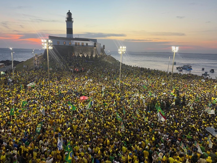 Multidão vestida de verde e amarelo participa de ato político de Flávio Bolsonaro na orla da Barra, em Salvador, na Bahia.